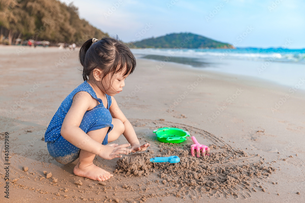 little girl 2-3 years plays on the beach in sunset little girl 2-3 years plays on the beach in sunset