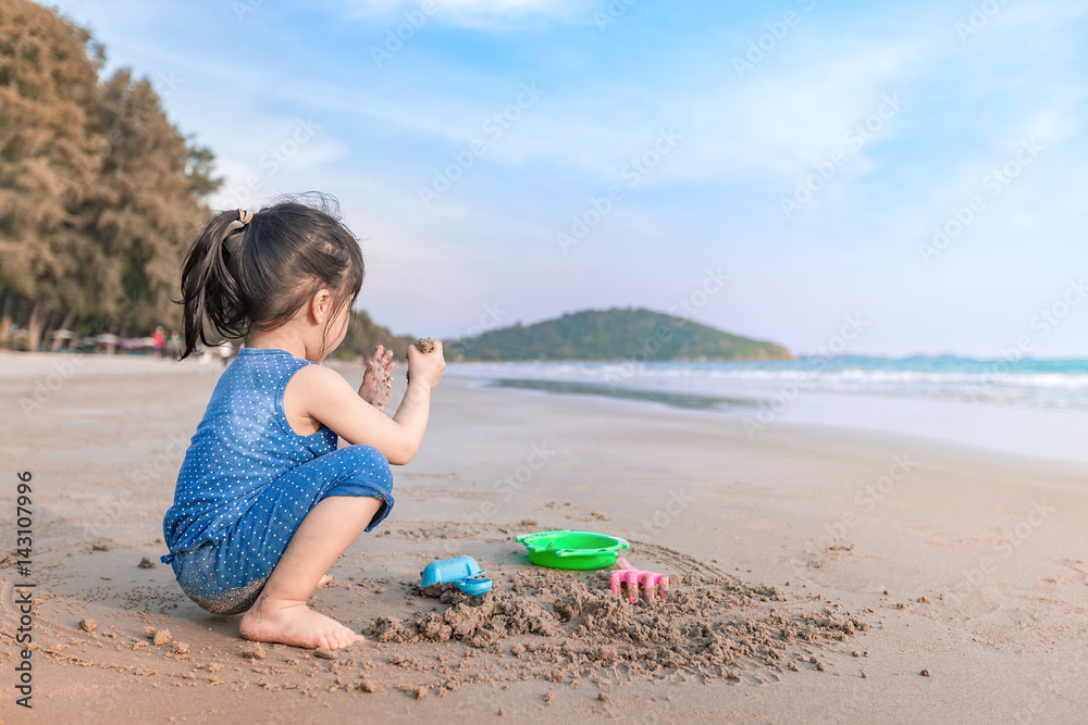 little girl 2-3 years plays on the beach in sunset little girl 2-3 years plays on the beach in sunset