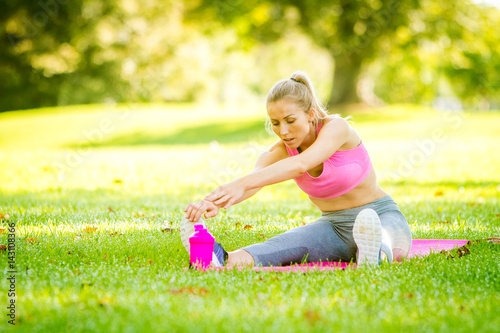 young happy smiling caucasian woman doing exercises in the park, outdoor fitness