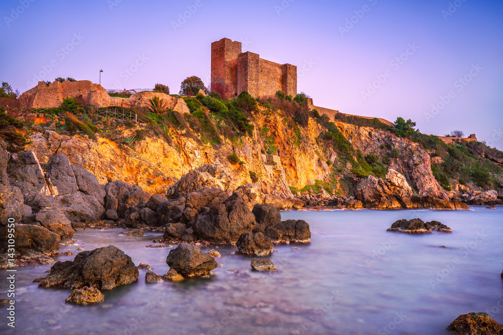 Talamone rock beach and medieval fortress at sunset. Maremma Argentario, Tuscany, Italy