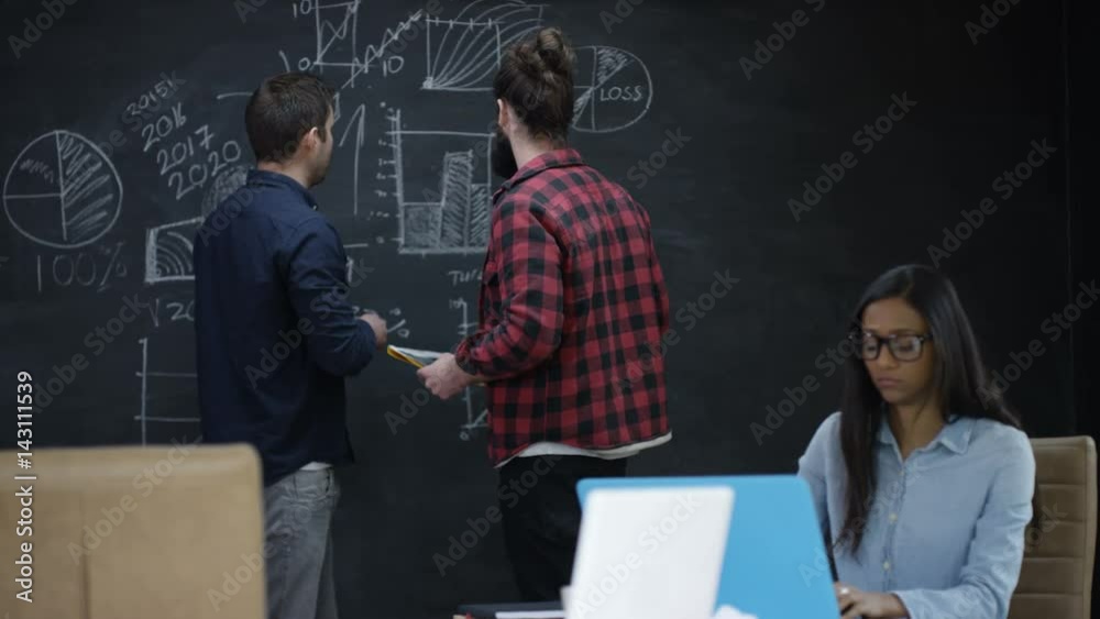 Young professional team in startup company discussing business plan Young professional team in startup company discussing business plan