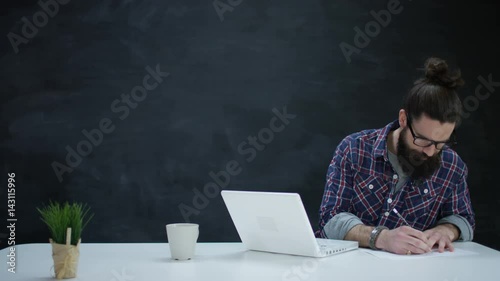  Man with laptop writing down ideas, screws up paper & throws it away
