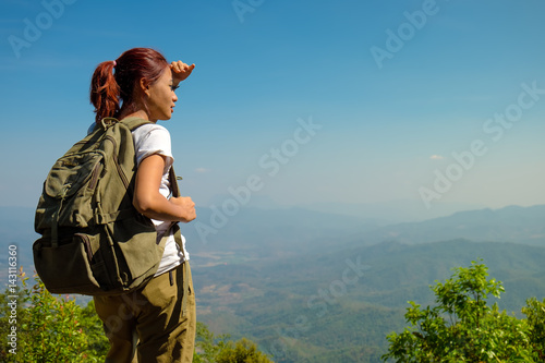 successful woman backpacker hiking on sunrise mountain peak cliff