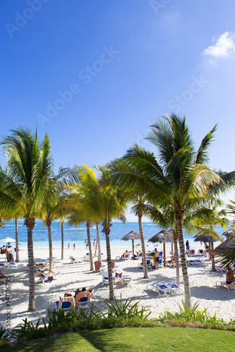 Vacation in the paradise. Sun bed coconut trees and white sand next to a turquoise water. © Jne Valokuvaus
