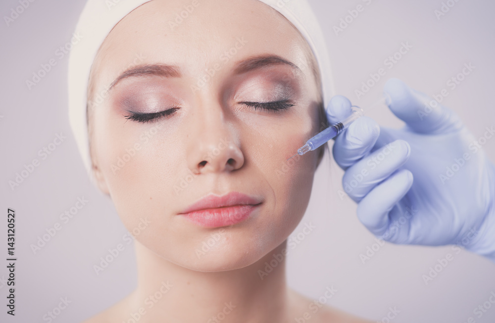 Cosmetic injection the pretty woman face. Isolated on gray background