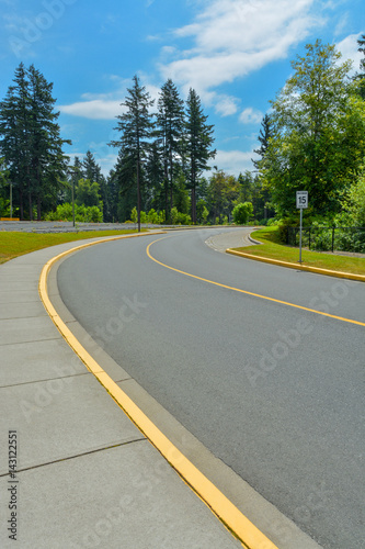 Road curve with 15km/h speed limit leading to the forest photo