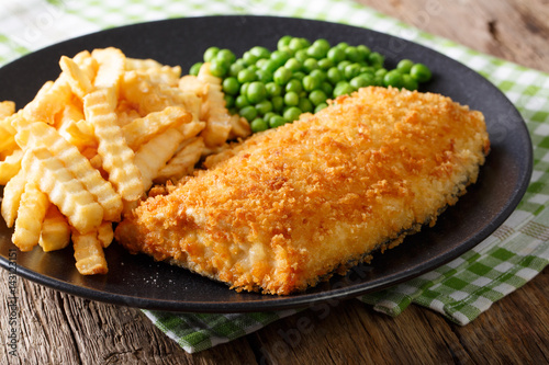 Fish and chips with green peas close-up on a plate. horizontal