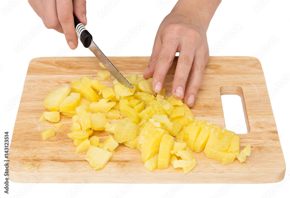 Chef cuts boiled potatoes on board on a white background Chef cuts boiled potatoes on board on a white background