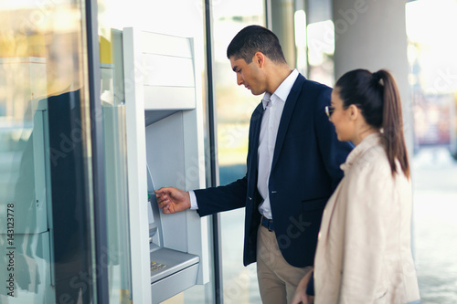 Εκτύπωση καμβά Young people with credit card standing next to the ATM to withdraw money