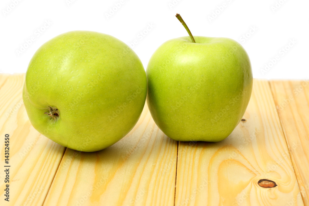 Green apple on wood table isolated on white background Green apple on wood table isolated on white background