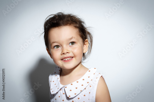 Close-up Portrait of 3 year old little girl with dress, Smiling on bright white background