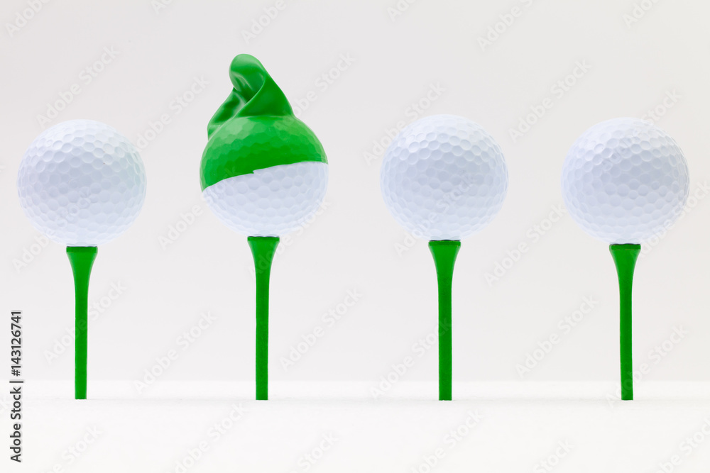 White golf balls with funny cap. Funny golf concept. White golf balls with funny cap. Funny golf concept.