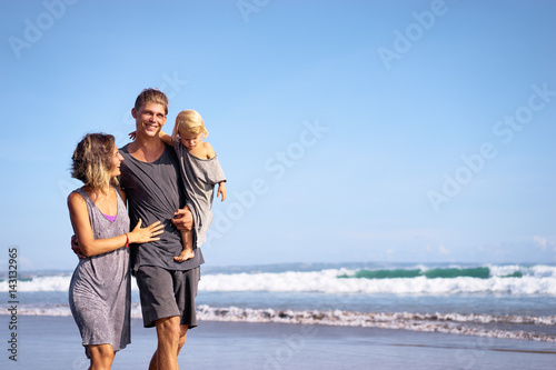 Vacation near the sea. Family with little kid walking on the beach. © luengo_ua