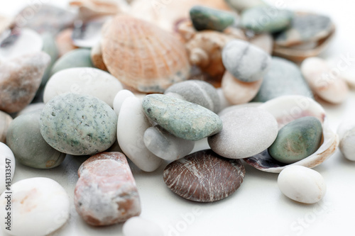 Stones and seashells in a vase on a white background. Reminder of the sea