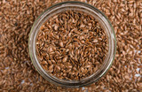 close up of flax seeds isolated on white background. Bowl full of brown flaxseed or linseed. Cereals. Vitamins. Healthy food.