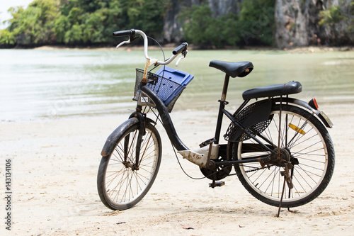 Vintage bicycle on white sand beach over blue sea