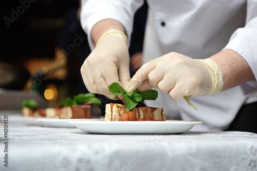 The confectioner decorates dessert