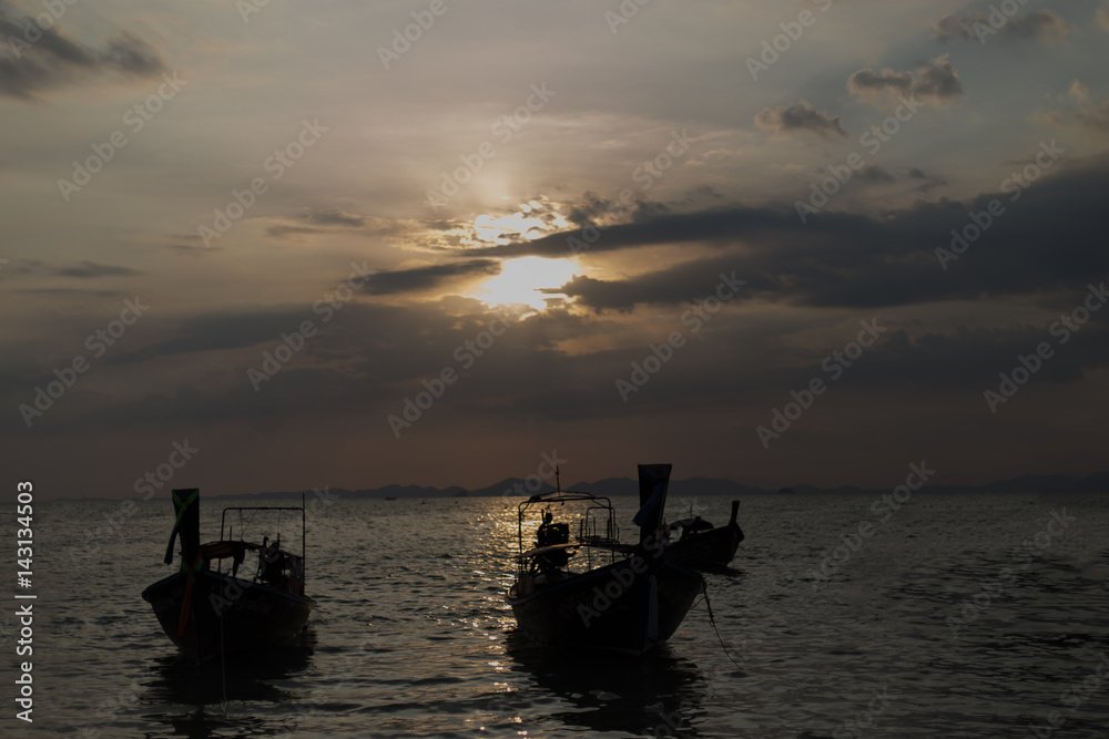 Traditional thai longtail boat at sunset on the Beach. Thailand, Krabi province Traditional thai longtail boat at sunset on the Beach. Thailand, Krabi province