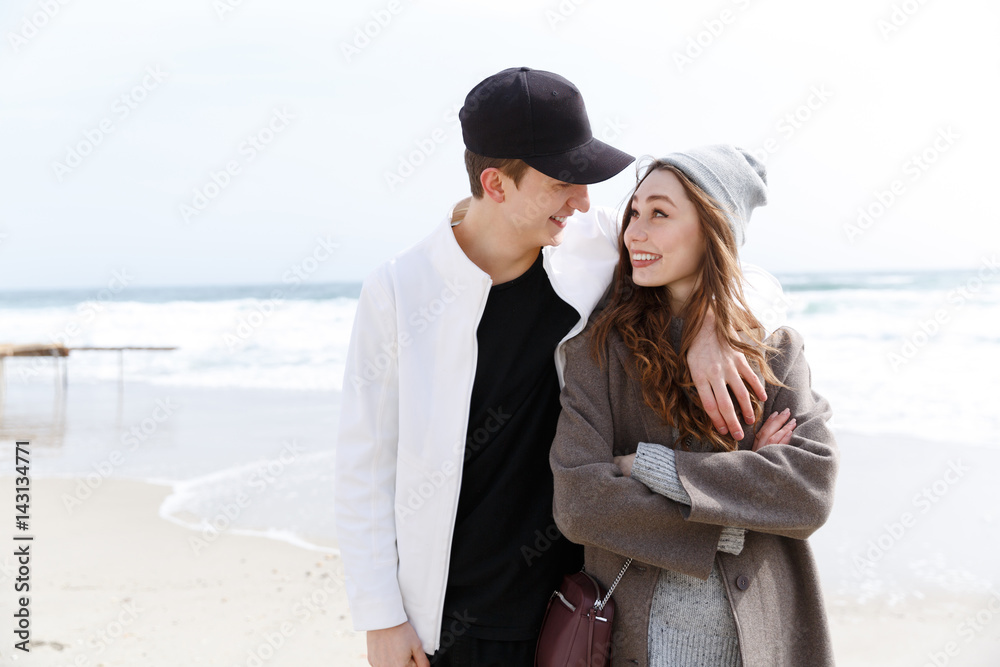 Happy young couple hugging on the beach in spring