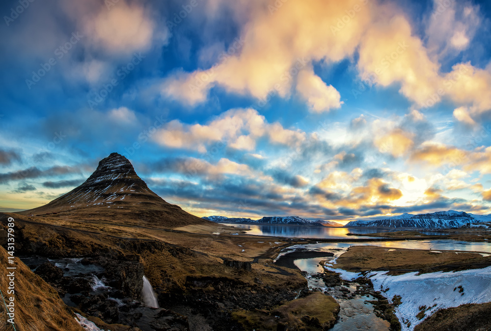 Spring sunrise over the famous Kirkjufellsfoss Waterfall with Kirkjufell mountain in the background in Iceland Spring sunrise over the famous Kirkjufellsfoss Waterfall with Kirkjufell mountain in the background in Iceland