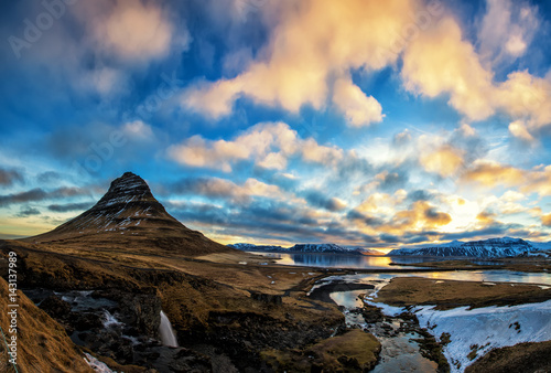 Spring sunrise over the famous Kirkjufellsfoss Waterfall with Kirkjufell mountain in the background in Iceland