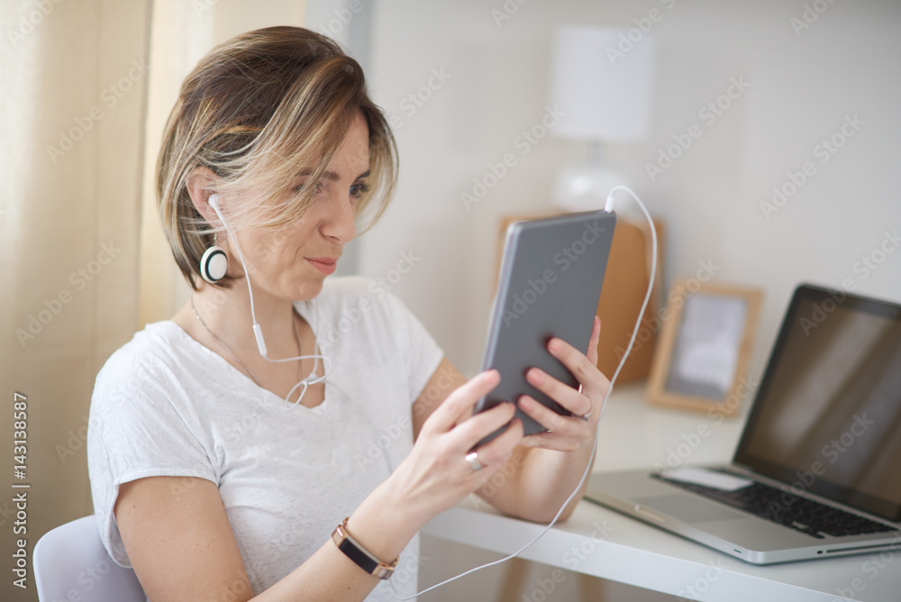 Young businesswoman using tablet computer in pause from freelancing while sitting in home office . Businesswoman in thirties concept Young businesswoman using tablet computer in pause from freelancing while sitting in home office . Businesswoman in thirties concept