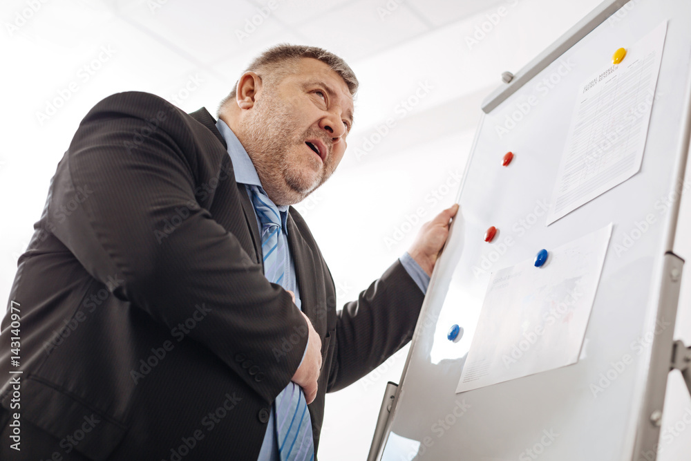 Fototapeta premium Overworked scared man suffering a heart seizure