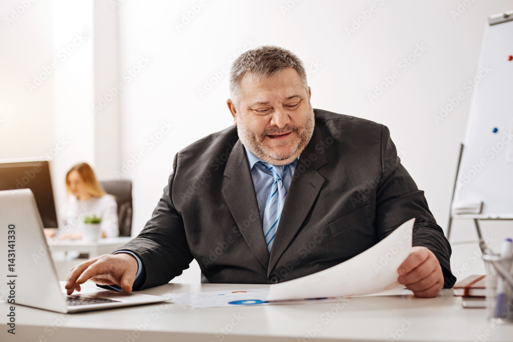 Pleasant middle aged worker looking delighted Pleasant middle aged worker looking delighted