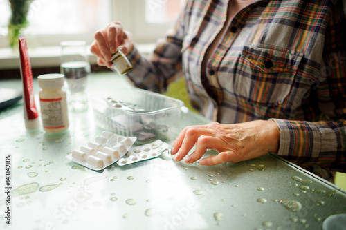 The woman having rheumatoid arthritis takes medicine.