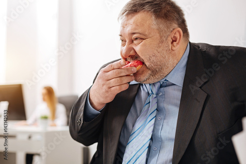 Compulsive immoderate guy engulfing junk food photo