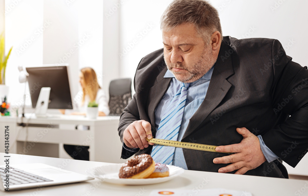Hilarious white collar worker using a measuring tape Hilarious white collar worker using a measuring tape
