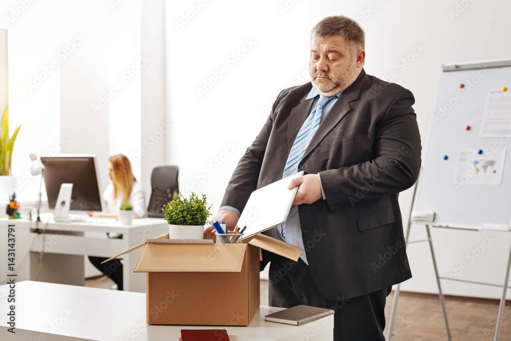 Disappointed ambitious employee leaving his workplace Disappointed ambitious employee leaving his workplace