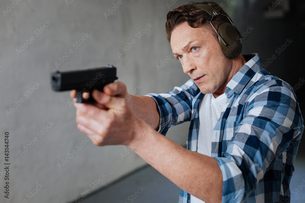 Nice serious man visiting the shooting range Nice serious man visiting the shooting range