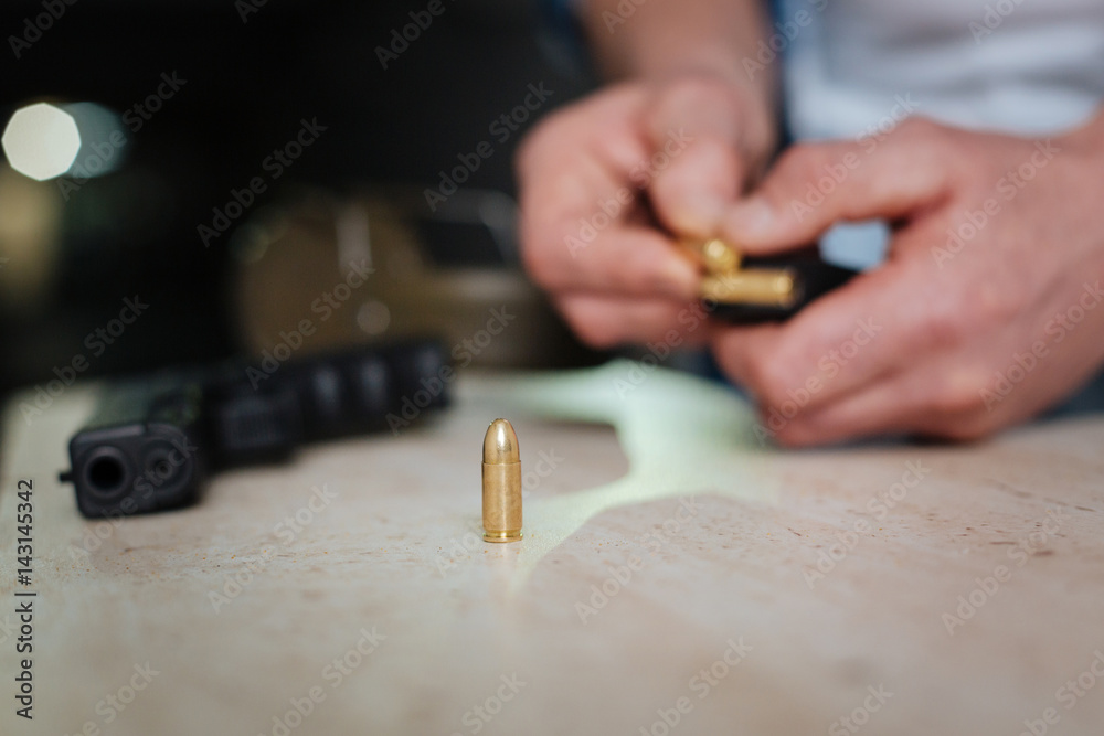 Selective focus of a bullet standing on the table Selective focus of a bullet standing on the table