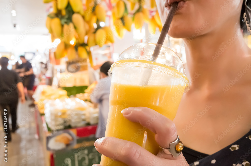 Fototapeta premium woman hold a mango juice