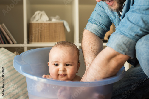 Father bathing his little baby photo