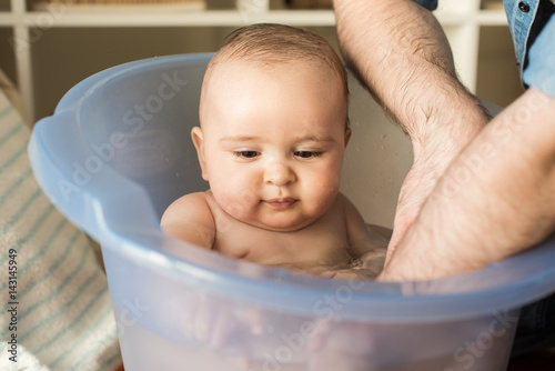 Father bathing his little baby photo