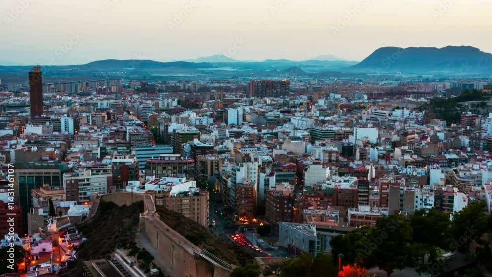 Costa Blanca, Spain. Aerial view of Alicante, Spain in the evening. It is a popular summer resort of Costa Blanca. Time-lapse, illumination at sunset. Mountains at the background Costa Blanca, Spain. Aerial view of Alicante, Spain in the evening. It is a popular summer resort of Costa Blanca. Time-lapse, illumination at sunset. Mountains at the background