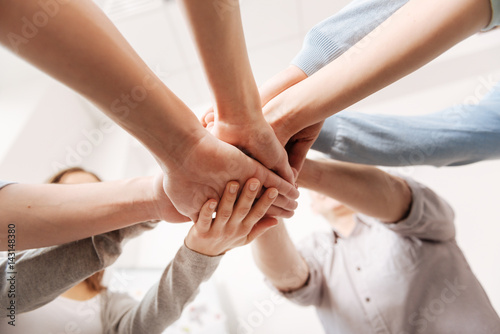 Close up of coworkers hands being united