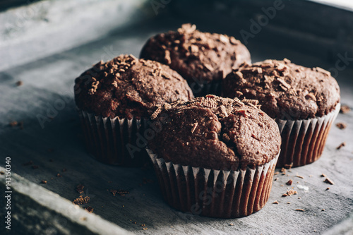 Chocolate muffins on gray wooden tray
