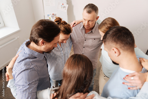 Attentive man standing with his coworkers