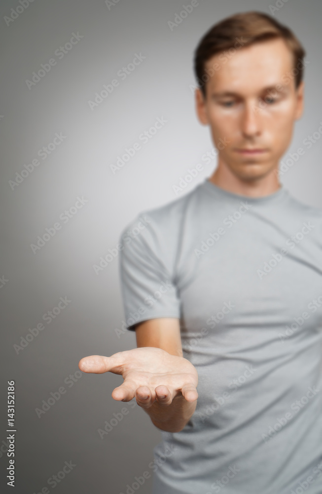 Man holding something blank in his hand on a grey background. Man holding something blank in his hand on a grey background.