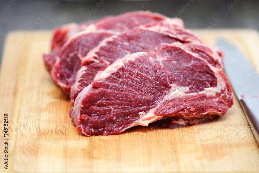 Appetizing raw beef or veal meat on wooden cutting board