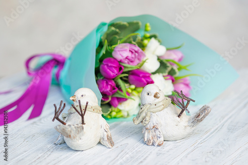 Wedding decoration of a beautiful delicate flower bouquet and two ceramic birdies