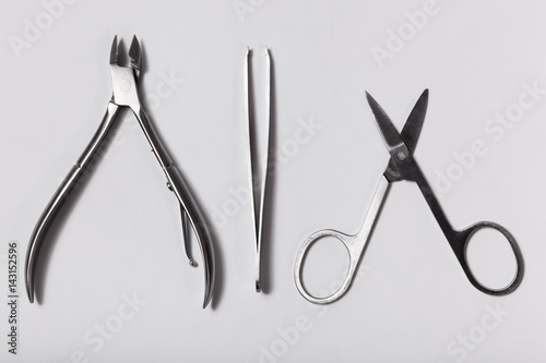 Nail clippers, cosmetic tweezers and nail scissors on white background