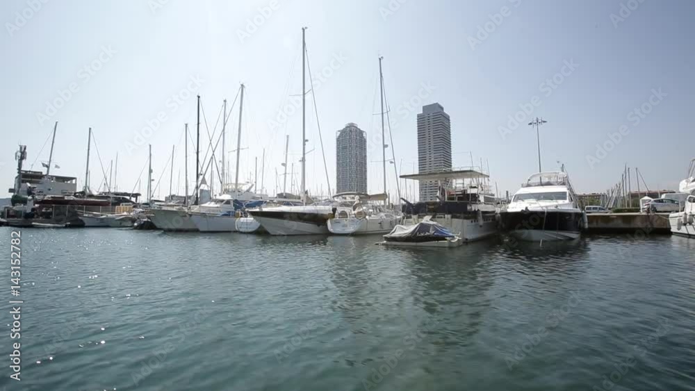 Boats docked in harbor in Marcelona, Spain. View of many luxury yachts docked in the port on a sunny summer or spring day. Vacation, luxury lifestyle concept. Boats docked in harbor in Marcelona, Spain. View of many luxury yachts docked in the port on a sunny summer or spring day. Vacation, luxury lifestyle concept.