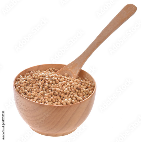 Coriander seeds in wooden bowl on white background