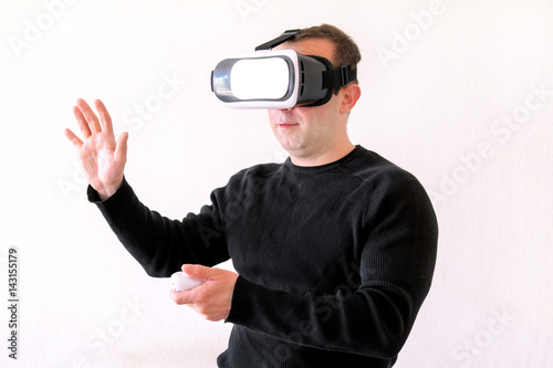 Man using a virtual glasses on white background. Young male business executive using virtual reality headset in office. Gays at office and using virtual reality glasses.