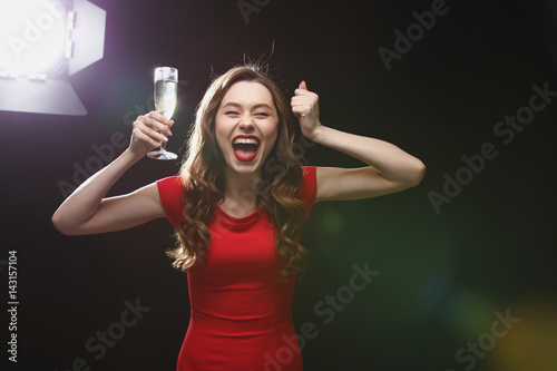 Happy excited woman with glass of champagne standing and shouting © Drobot Dean