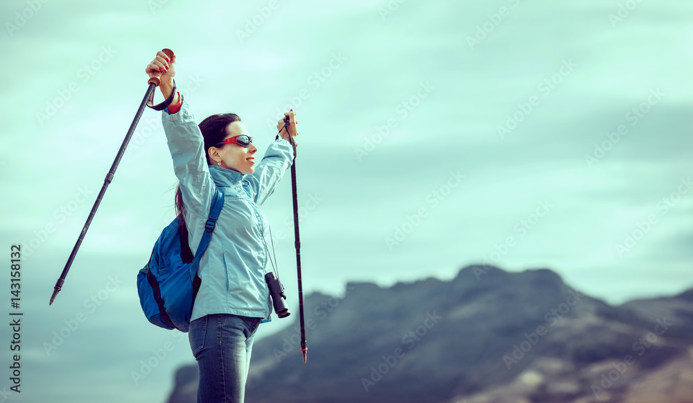 Naklejka premium Young traveler with backpack standing on the big stones